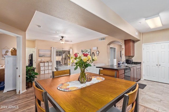 dining room with light hardwood / wood-style floors, sink, and ceiling fan