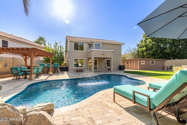 view of pool featuring a patio, an outbuilding, pool water feature, central AC unit, and a gazebo