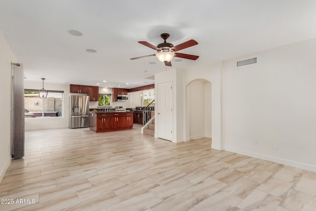 unfurnished living room featuring ceiling fan