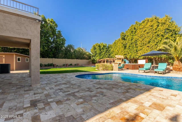 view of pool featuring an outbuilding, a jacuzzi, a patio area, and central air condition unit