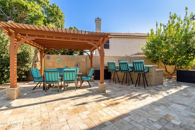 view of patio featuring exterior bar and a pergola