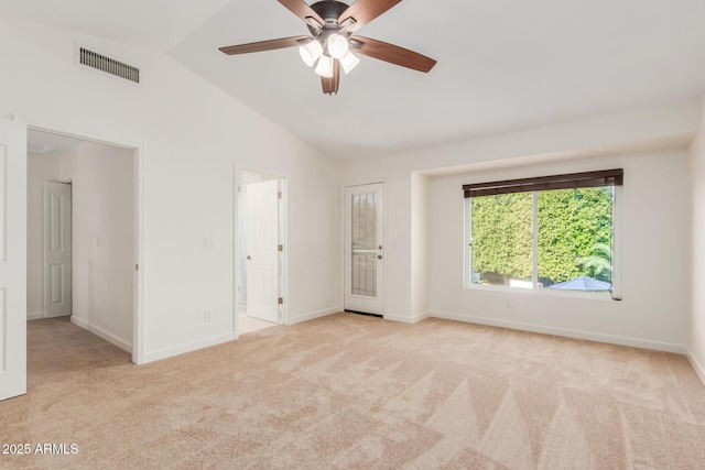 spare room with ceiling fan, lofted ceiling, and light carpet