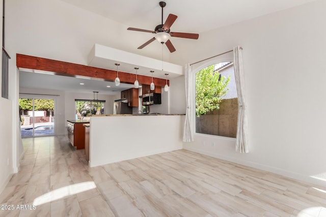 kitchen with lofted ceiling, decorative light fixtures, kitchen peninsula, ceiling fan, and stainless steel appliances