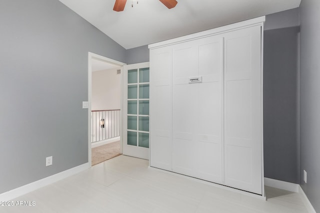 unfurnished bedroom with ceiling fan, vaulted ceiling, and a closet