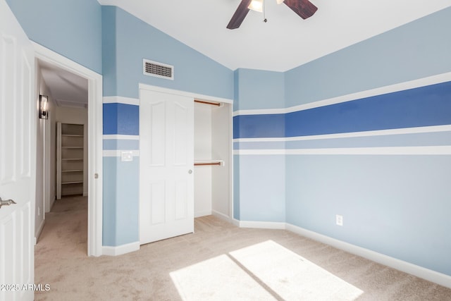 unfurnished bedroom featuring ceiling fan, a closet, vaulted ceiling, and light carpet