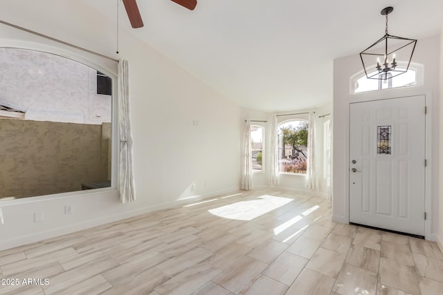 entryway featuring lofted ceiling and ceiling fan with notable chandelier