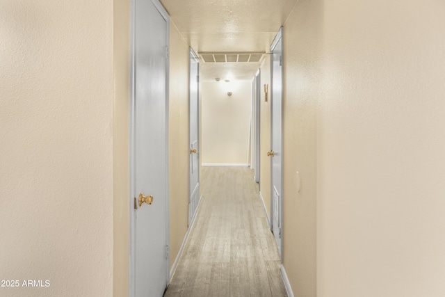 corridor with light hardwood / wood-style floors