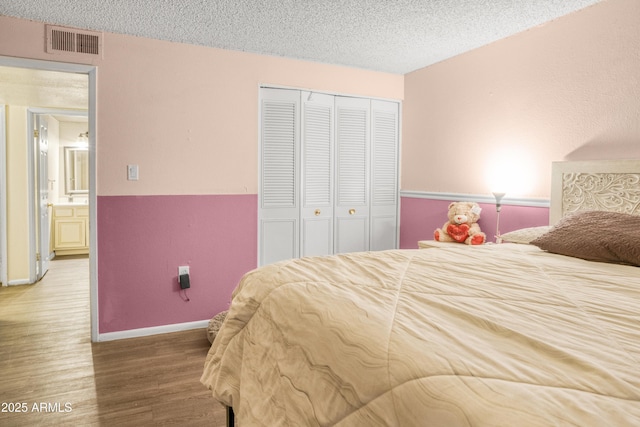 bedroom featuring wood-type flooring, a closet, and a textured ceiling