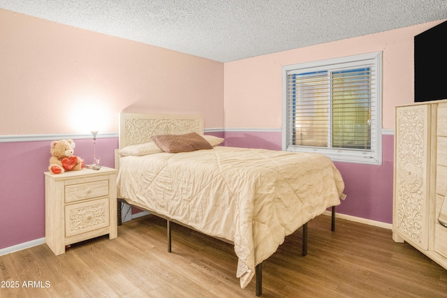 bedroom featuring hardwood / wood-style floors and a textured ceiling