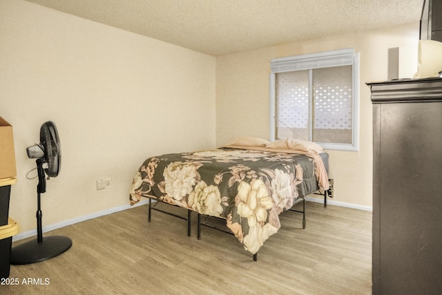 bedroom featuring a textured ceiling and light wood-type flooring