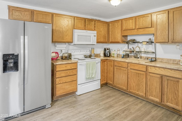 kitchen with sink, white appliances, and light wood-type flooring