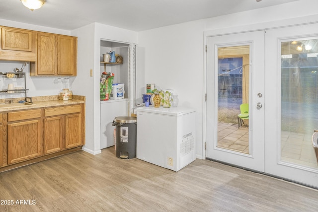 kitchen with french doors, refrigerator, and light hardwood / wood-style floors