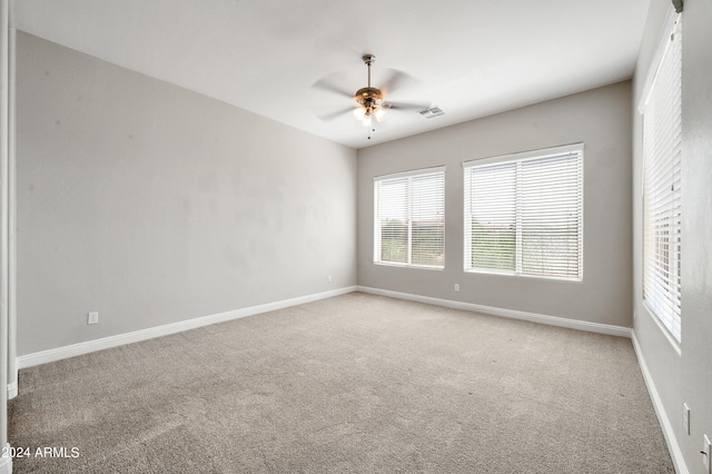 spare room featuring light colored carpet and ceiling fan