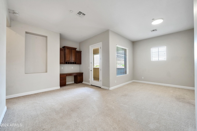 unfurnished living room with built in desk