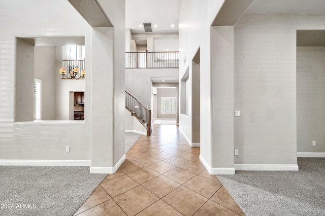 entrance foyer featuring a towering ceiling and light tile patterned floors