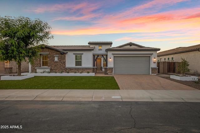 3038 E Longhorn Dr, Gilbert, AZ 85297 - prairie-style house with stone siding, decorative driveway, stucco siding, a garage, and a yard