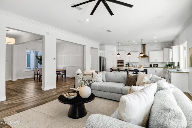 3038 E Longhorn Dr, Gilbert, AZ 85297 - living room featuring wood finished floors, crown molding, a ceiling fan, recessed lighting, and baseboards