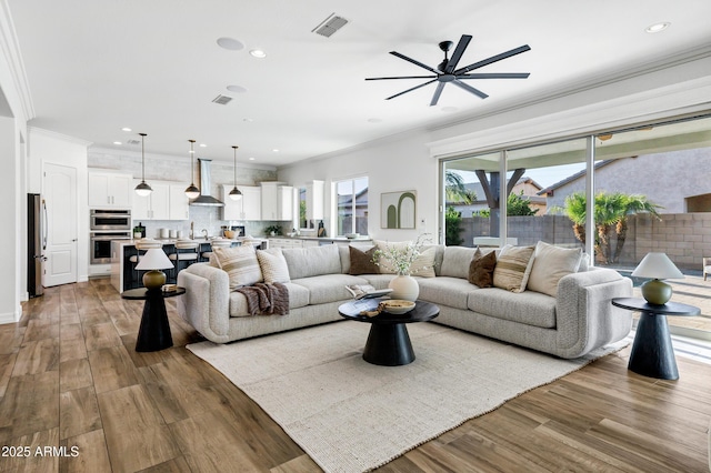 3038 E Longhorn Dr, Gilbert, AZ 85297 - living room featuring ceiling fan, ornamental molding, recessed lighting, and wood finished floors