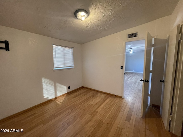 empty room featuring light hardwood / wood-style flooring and a textured ceiling