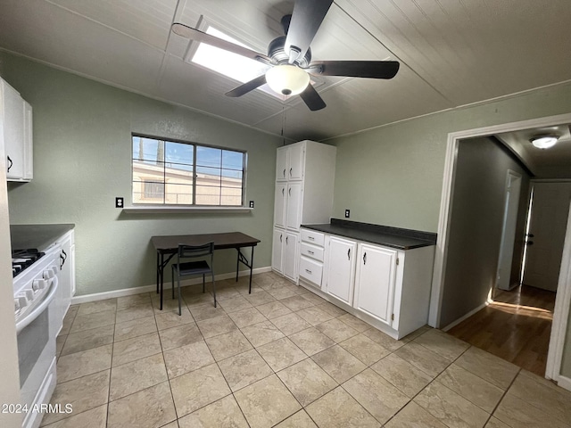 kitchen featuring white cabinetry, white range with gas stovetop, and light tile patterned flooring