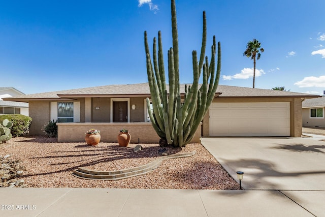 view of front of property with stucco siding, an attached garage, and concrete driveway