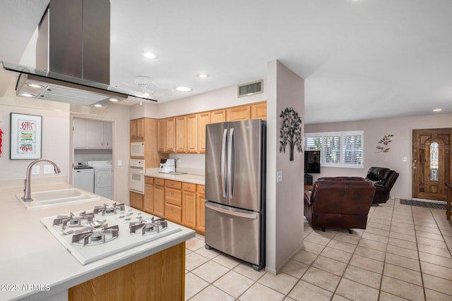 kitchen featuring a sink, white appliances, separate washer and dryer, light countertops, and light tile patterned floors