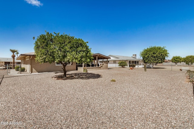 view of front facade featuring stucco siding, a patio, and fence