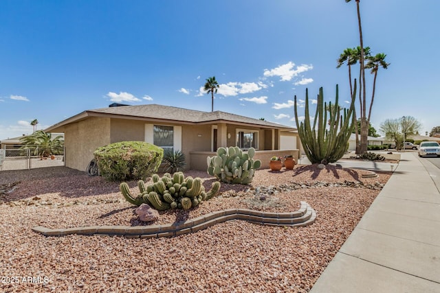 ranch-style home featuring stucco siding and fence