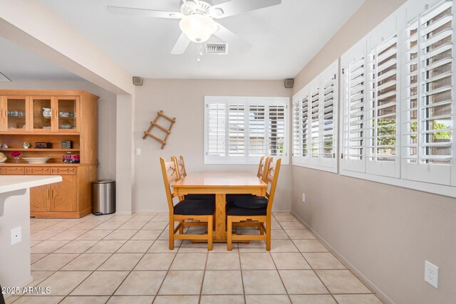 dining space with light tile patterned floors, visible vents, baseboards, and ceiling fan