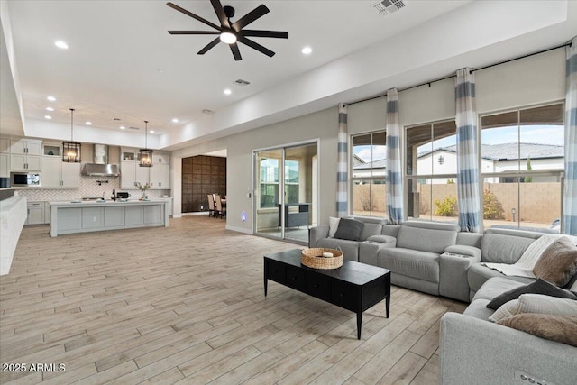 living room featuring light hardwood / wood-style flooring and ceiling fan