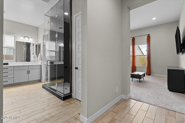 bathroom with vanity, a wealth of natural light, and walk in shower