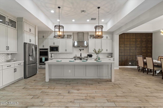 kitchen with stainless steel appliances, a kitchen island with sink, and pendant lighting