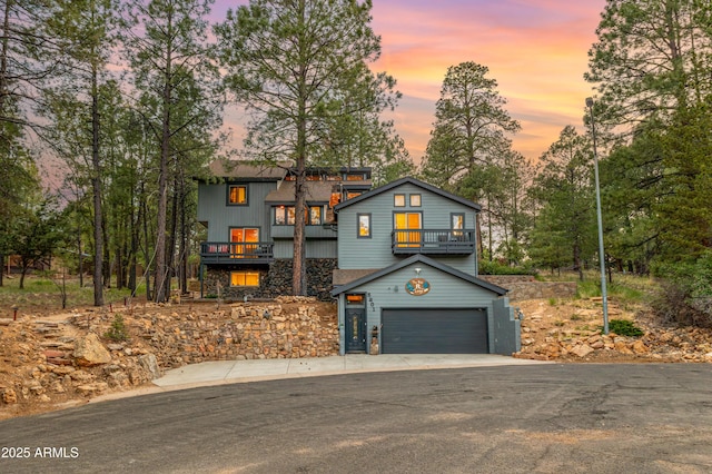 5201 E Duquesne Ln, Flagstaff, AZ 86004 - view of front of property featuring a balcony, asphalt driveway, an attached garage, and stone siding
