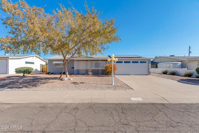 ranch-style home with solar panels and a garage