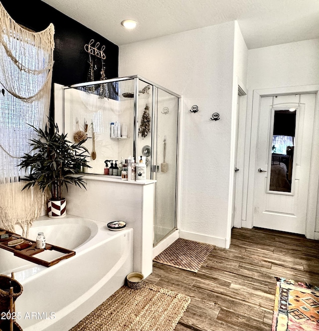 bathroom featuring hardwood / wood-style flooring, plus walk in shower, and a textured ceiling