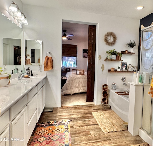 bathroom featuring a washtub, vanity, and ceiling fan