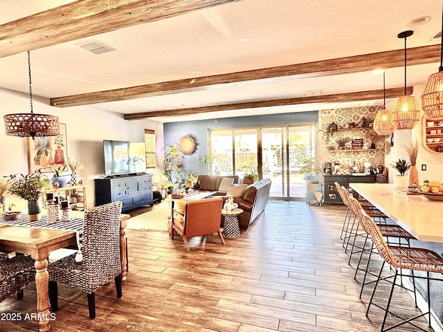 dining area with beamed ceiling and light hardwood / wood-style flooring