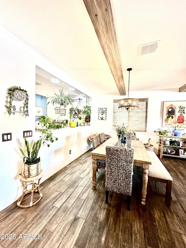 dining area with wood-type flooring and beamed ceiling