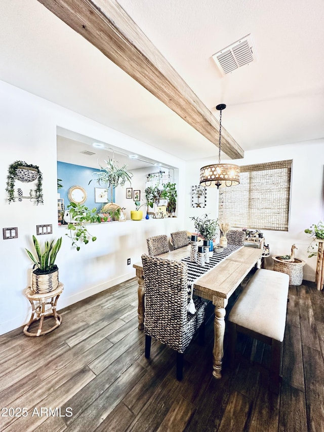 dining space with dark wood-type flooring and beam ceiling