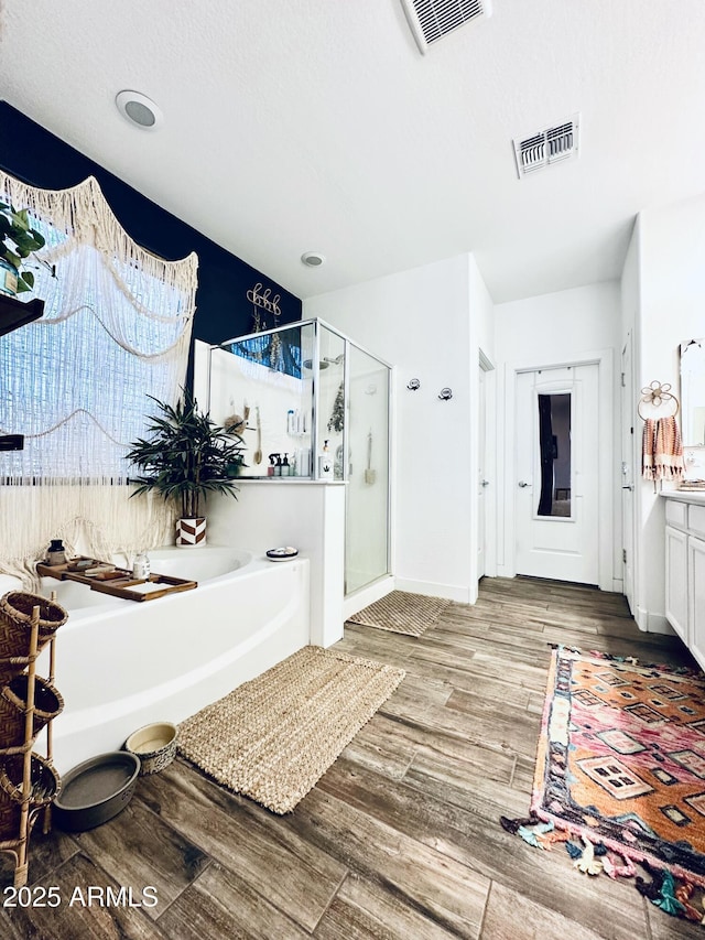 bathroom featuring hardwood / wood-style flooring, vanity, and shower with separate bathtub