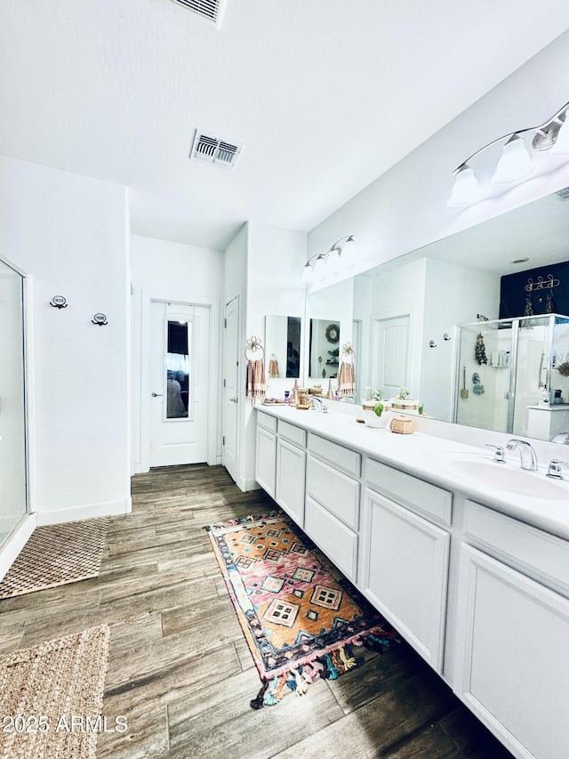 bathroom featuring vanity, hardwood / wood-style floors, and a shower with shower door