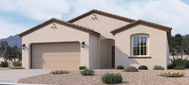 mediterranean / spanish-style home featuring a garage, concrete driveway, stucco siding, and a mountain view