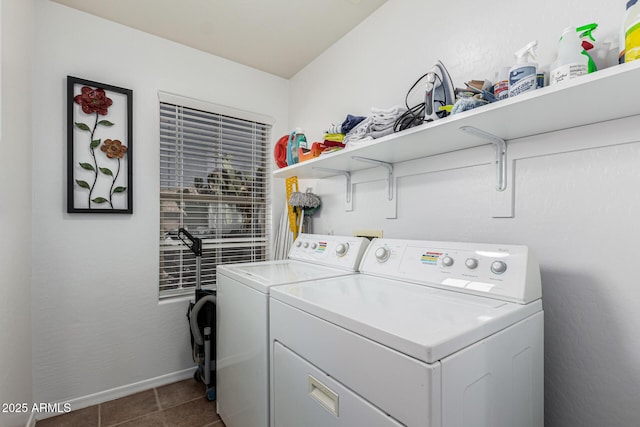 laundry area featuring washer and dryer and dark tile patterned floors