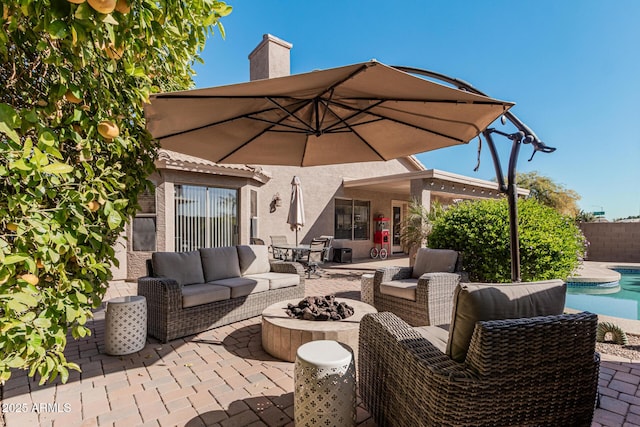 view of patio / terrace with a fenced in pool and an outdoor living space with a fire pit