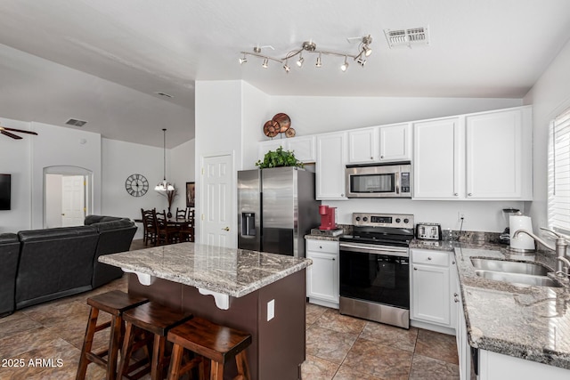 kitchen featuring sink, a kitchen island, white cabinetry, and appliances with stainless steel finishes