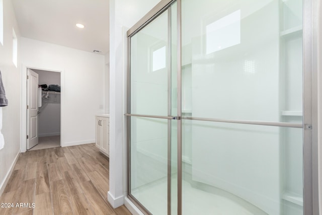 bathroom featuring a shower with shower door, vanity, and hardwood / wood-style flooring