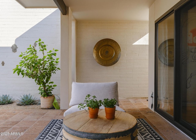 entrance to property featuring brick siding and a patio area