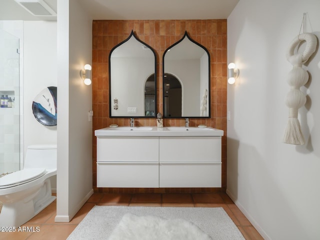 full bath featuring double vanity, visible vents, toilet, a sink, and tile patterned floors