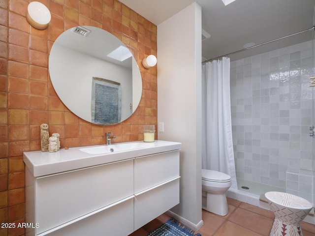 full bathroom with a tile shower, vanity, toilet, and tile patterned floors