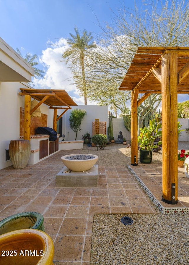 view of patio / terrace with an outdoor fire pit, area for grilling, fence, a grill, and a pergola